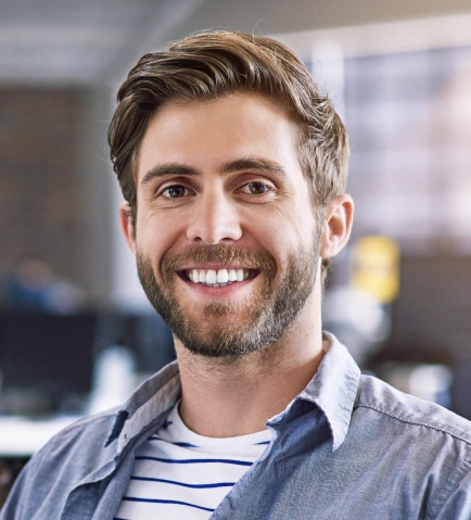 Smiling man in casual striped shirt in modern dental office setting