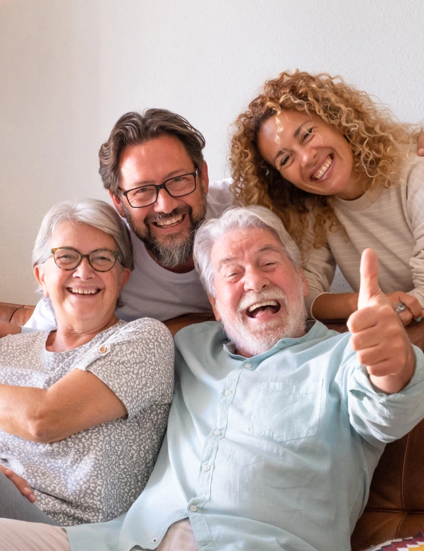 Happy multi-generational family smiling together indoors at dental care office.