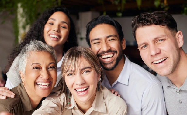 Group of smiling people posing together indoors for dental care practice portrait