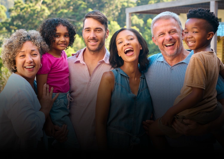 Diverse group of smiling patients and staff posing together outdoors at Dr. Bob's Dental Care.