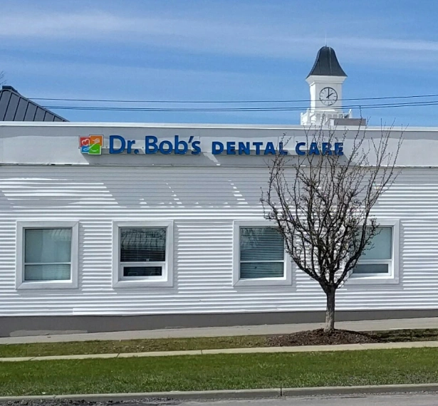 Dr. Bob's Dental Care clinic exterior with white building, blue signage, and clock tower.